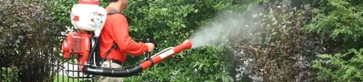 Mosquito control technician fogging shrubs and landscaping for mosquito treatment in Shreveport, LA